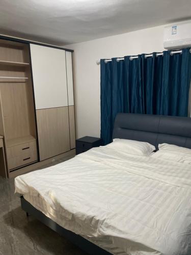 sypialnia z łóżkiem i niebieską zasłoną w obiekcie sunny apartment w mieście Koolbaai