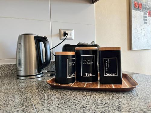 three coffee mugs on a wooden tray on a kitchen counter at Depto 1 Dormitorio 1504 Central in Temuco