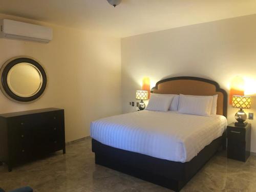 - une chambre avec un grand lit et un miroir dans l'établissement Tres Iguanas - Sea view terrace, new spacious & cozy flat, short walk to beach, à Loreto