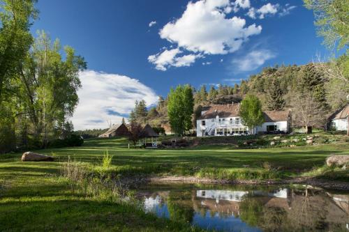 a house on a golf course with a pond at Antlers on the Creek Bed & Breakfast in Durango