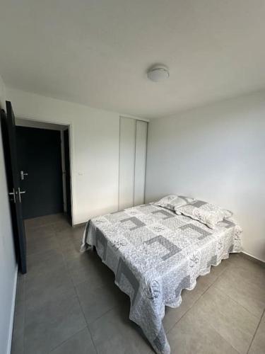 - une chambre blanche avec un lit dans l'établissement Appartement F2, à Fort-de-France