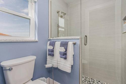 uma casa de banho com um WC e um chuveiro com toalhas em Anchors Away - Pool with Spa - Garage Game Room em Cape Coral