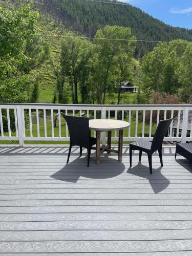 a table and two chairs on a wooden deck at Antlers on the Creek Bed & Breakfast in Durango