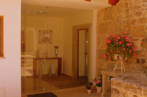 a bathroom with a vase of flowers on a table at Otium Country House in Alvorge