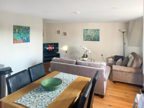 uma sala de estar com uma mesa e um sofá em Entire Apartment in Central Brockenhurst em Brockenhurst