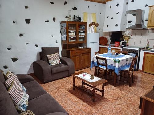 sala de estar con mesa y sillas y cocina en Casa da Queijaria en Faja Grande