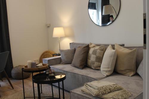 uma sala de estar com um sofá e um espelho em Boutique Apartment im Zentrum em Paderborn