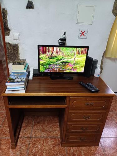a television sitting on a wooden desk at Casa da Queijaria in Faja Grande