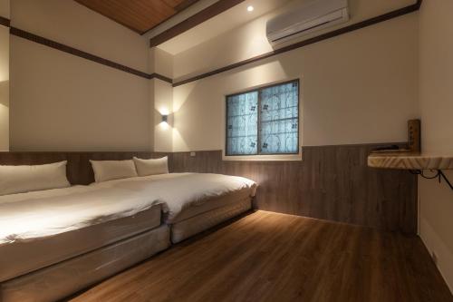 a bedroom with a bed and a window at Pine Tree Resort  in Zhushan