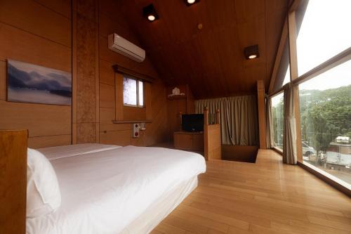竹山Pine Tree Resort 的一间带大床和大窗户的卧室