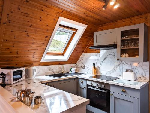 a kitchen with a wooden ceiling and a window at Macha 3 - Hot Tub-Perth-Pets-Family-Luxury-Cabin in Perth