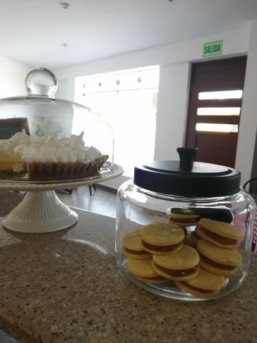 a glass jar filled with cookies and a cake on a counter at Casa Yuraq Hotel Boutique in Chincha Alta