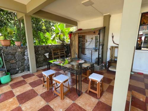 eine Terrasse mit einem Tisch, Stühlen und einer Theke in der Unterkunft Kowlessur Residence in Surinam