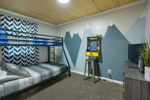 a room with a bed and a video game machine at Hideaway Pines in Logan