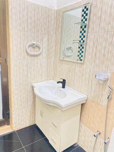a bathroom with a sink and a mirror at Christina Residence in Dar es Salaam