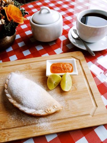 a cutting board with a tortilla and a plate of food at Casa Yuraq Hotel Boutique in Chincha Alta