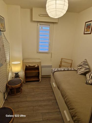 Habitación pequeña con cama y ventana en Appartement "La Mouette" 3 etoiles, en Saint-Philibert