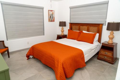 a bedroom with a bed with an orange blanket at Mid-Century Modern Retreat in Mission