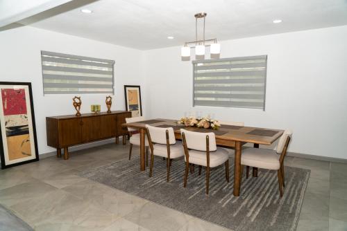 a dining room with a wooden table and chairs at Mid-Century Modern Retreat in Mission