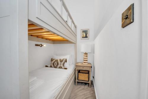 a small white room with a bed and a table at Charming Church Walk, Long Melford - 2 bedroom property with parking in Long Melford