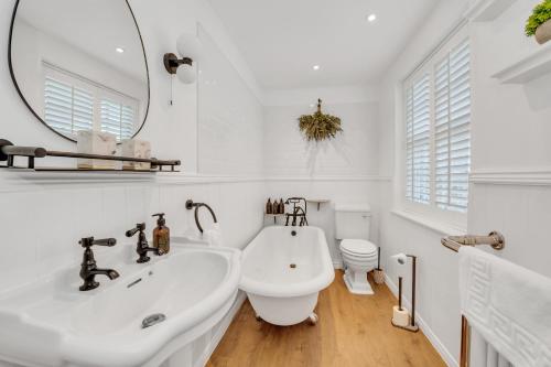 a white bathroom with a sink and a toilet at Charming Church Walk - 2 bedroom property with parking in Long Melford