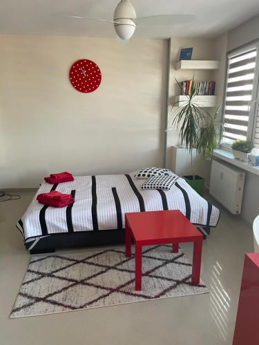 - une chambre avec un lit et un tabouret rouge dans l'établissement AS Apartment Lodz, à Łódź