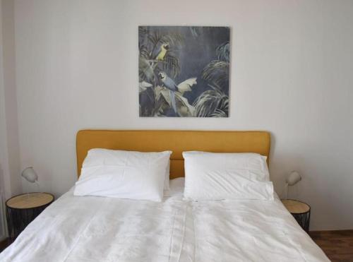 a bed with two pillows and a painting above it at Modern Cozy Central Flat in Patra