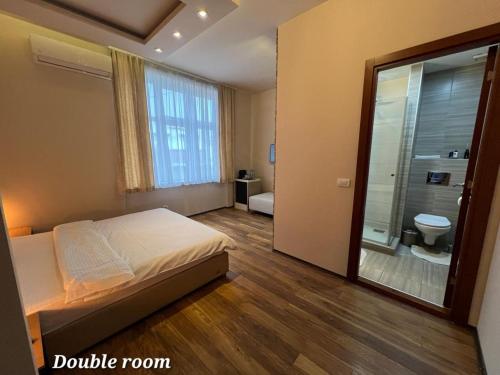 a bedroom with a bed and a bathroom with a toilet at Metropolitan Rooms in Belgrade