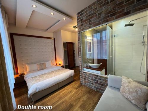 sypialnia z łóżkiem i przeszklonym prysznicem w obiekcie Metropolitan Rooms w Belgradzie