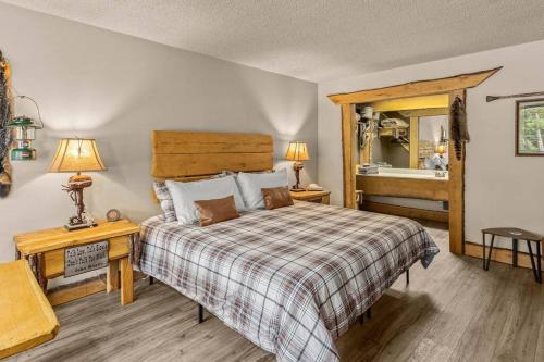 a bedroom with a bed with a checkered bedspread at Stonegate Lodge Fire Pit 50in TV Salt Water Pool Fast Wi-Fi Room #301 in Eureka Springs