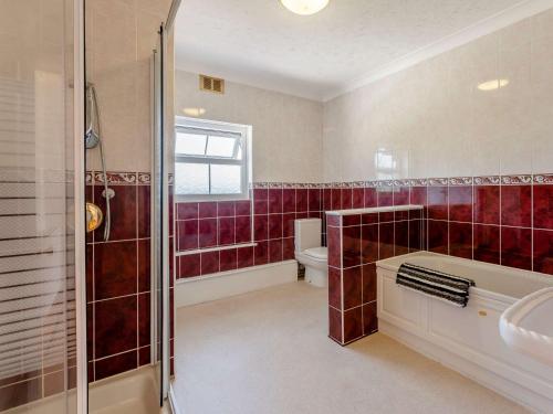 y baño con ducha, aseo y lavamanos. en 2 bed property in Ventnor 82973 en Wroxall