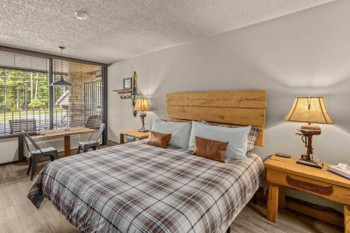 een slaapkamer met een bed, een bureau en een raam bij Stonegate Lodge Fire Pit 50in TV Salt Water Pool Fast Wi-Fi Room #301 in Eureka Springs