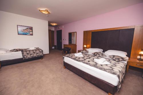 a hotel room with two beds and a desk at Etno selo Stanišići Hotel Leonida in Dijelovi