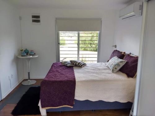 un grand lit dans une chambre avec une fenêtre dans l'établissement Casa en La Paloma cerca de la playa, à La Paloma