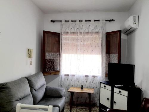 ein Wohnzimmer mit einem Sofa und einem Fenster in der Unterkunft CASA DE PUEBLO Fuente Buena in Arroyo del Ojanco