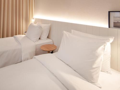 a hotel room with two beds and a table at Intercity Florianopolis in Florianópolis