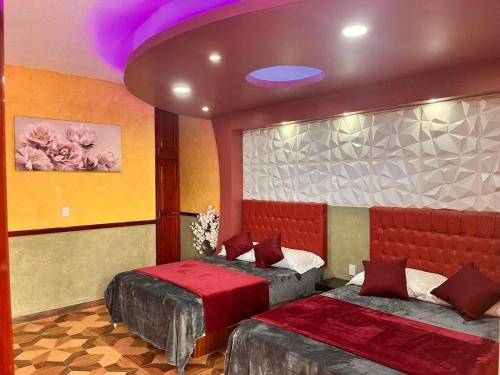 a bedroom with two beds and a purple ceiling at Hotel La Cueva del Pirata in Las Casitas
