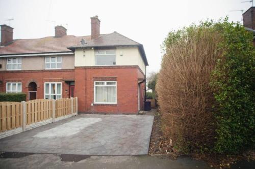 een rood bakstenen huis met een houten hek bij Lovely 2 Bedroom House Sheffield Central Location in Sheffield