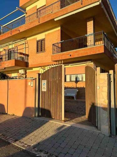 a building with a fence and a bench in front of it at Casa Vacanze Vanessa House in Ladispoli