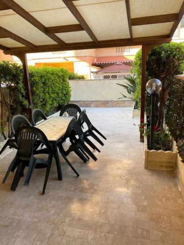 a patio with a table and chairs on a patio at Casa Vacanze Vanessa House in Ladispoli