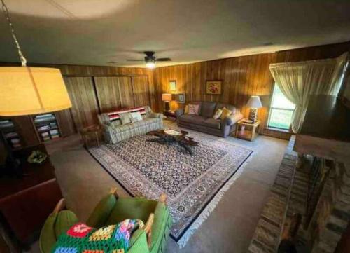 Large 3 Bedroom 70's Home - Benton, AR في بينتون: غرفة معيشة مع أريكة وسجادة