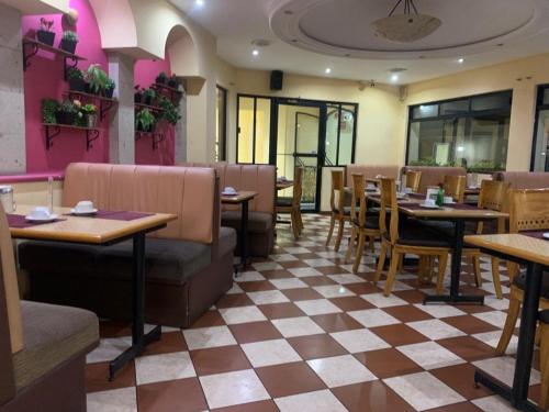 a restaurant with tables and chairs and a checkered floor at HOTEL VILLA LAS ROSAS TEPIC in Tepic