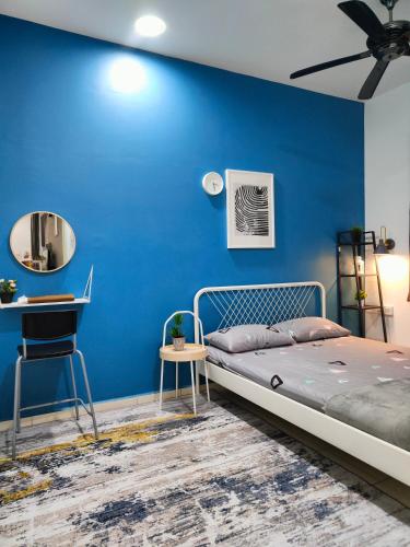 MerlimauにあるDH Merlimau Homestayの青い壁のベッドルーム(ベッド1台、デスク付)