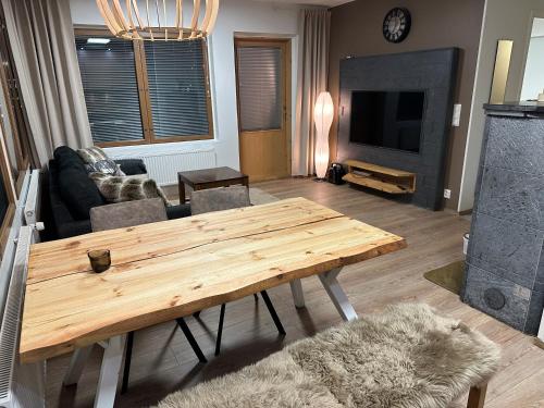 uma sala de estar com uma mesa de madeira e um sofá em Karhunvartijan Kartano 3 B 1, Rukan keskusta em Ruka