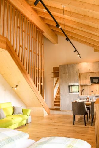 a living room with a yellow couch and a kitchen at Höra‘s Apartments Hammerbergblick in Münchberg
