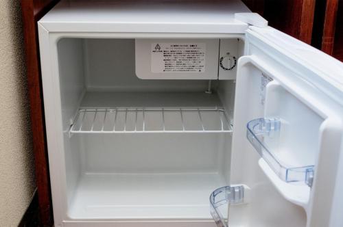 an empty refrigerator with its door open in a kitchen at Sky Heart Hotel Koiwa - Vacation STAY 51656v in Tokyo