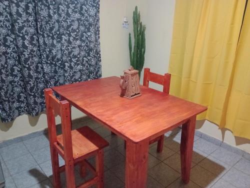 una mesa de madera con 2 sillas y una bolsa en ella en Casona el ancla en Eldorado