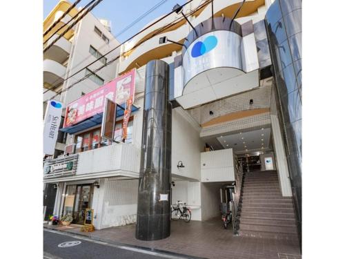 a building with a staircase in the middle of a street at Sky Heart Hotel Koiwa - Vacation STAY 51656v in Tokyo
