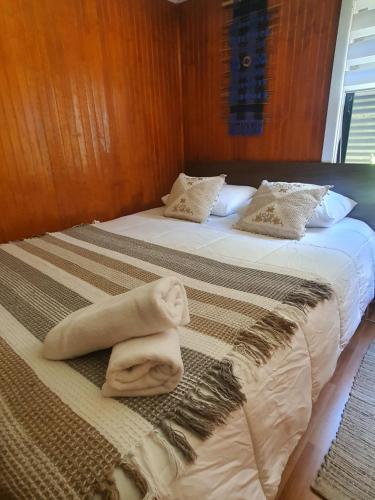 ein Hotelzimmer mit 2 Betten und Handtüchern darauf in der Unterkunft Hostal Isla Mágica in Castro