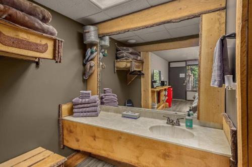 a bathroom with a sink and a large mirror at Stonegate Lodge 2 Queen Beds WIFI TV Salt Water Pool Fire Pits #303 in Eureka Springs